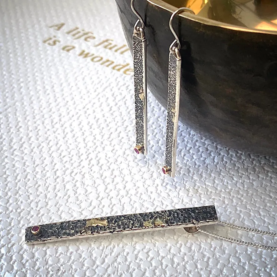 Solid sterling silver and gold earrings set with deep pink Rubies.